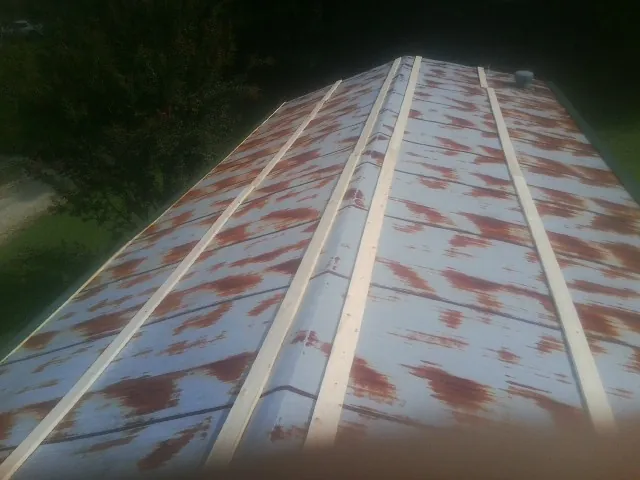 Rusted metal roof panels with new wood purlins before replacement — Storm Damage Roof Repair in Callaway by Roofing Brothers